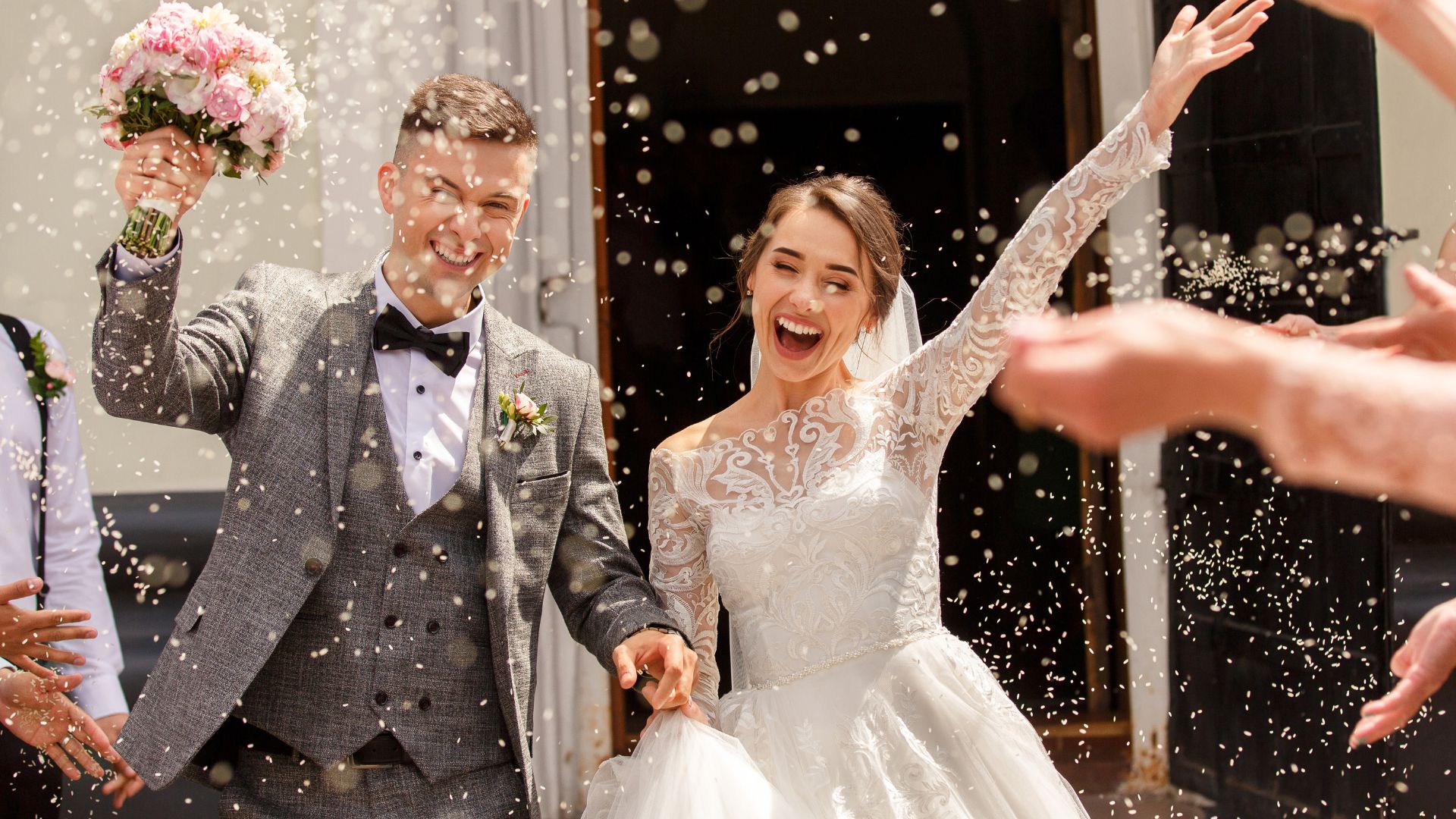A bride and groom are showered with confetti